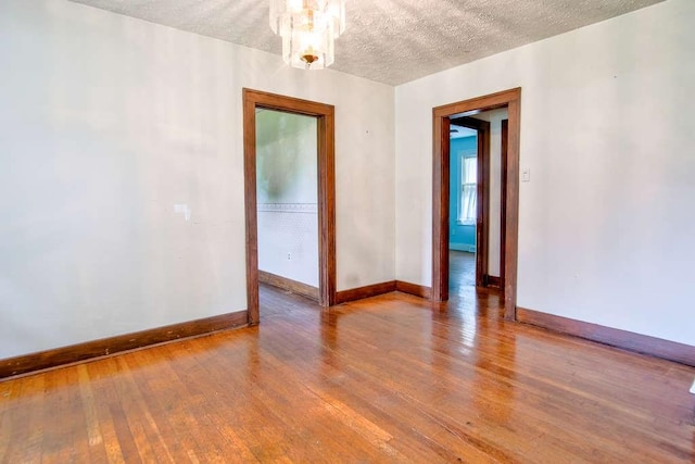 3444 Brodhead Rd, Center Twp, PA 15061 - unfurnished room with wood-type flooring, a textured ceiling, and a chandelier
