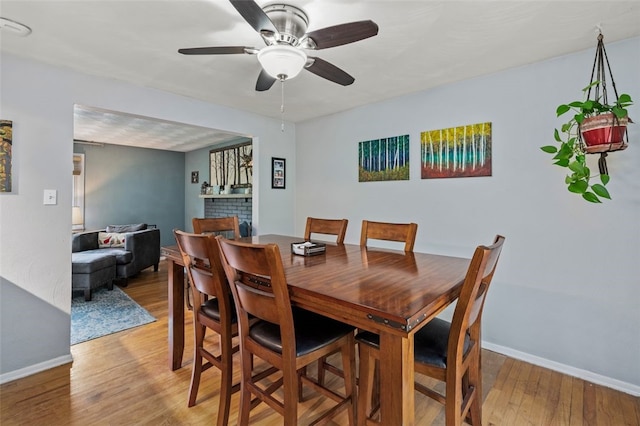 4 Thornridge Rd, Kilbuck Twp, PA 15202 - dining area with light wood-type flooring, a ceiling fan, and a brick fireplace