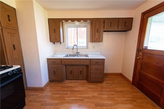 1819 Sundeman St, Troy Hill, PA 15212 - kitchen with range with gas stovetop, light countertops, light wood-style flooring, and brown cabinets