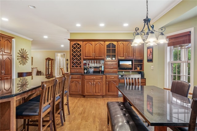 14 Amy Way S, Union Twp, PA 15401 - kitchen with brown cabinetry, a chandelier, ornamental molding, light wood-type flooring, and a kitchen bar