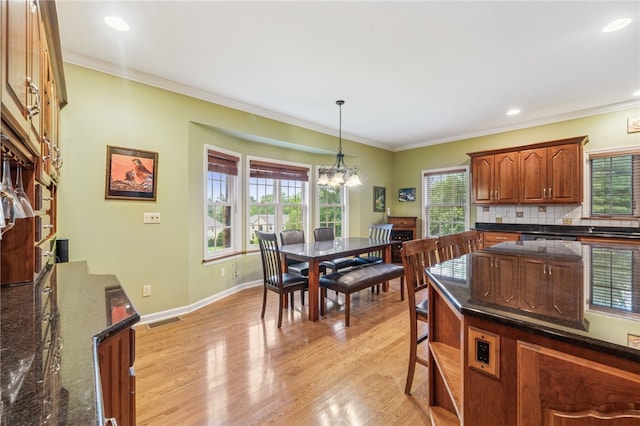 14 Amy Way S, Union Twp, PA 15401 - kitchen with light wood-type flooring, hanging light fixtures, dark stone counters, tasteful backsplash, and crown molding