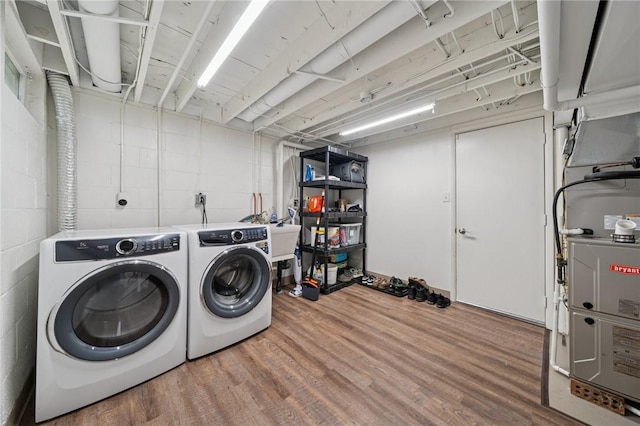 2047 Haymaker Rd, Monroeville, PA 15146 - laundry room featuring washing machine and clothes dryer, wood finished floors, concrete block wall, and heating unit