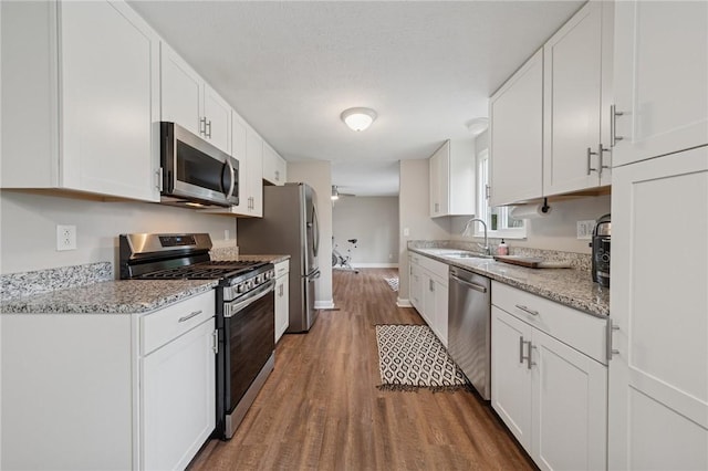 2047 Haymaker Rd, Monroeville, PA 15146 - kitchen with stainless steel appliances, wood finished floors, white cabinets, and light stone counters