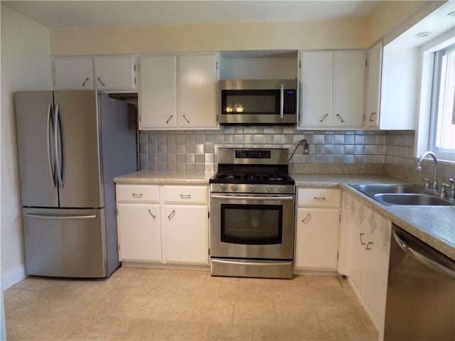 3055 Fadette St, Sheraden, PA 15204 - kitchen featuring appliances with stainless steel finishes, backsplash, light countertops, and white cabinetry