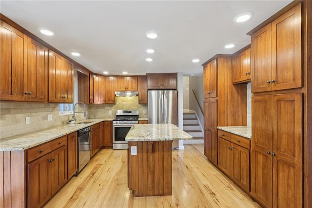 1717 Gina Dr, West Mifflin, PA 15122 - kitchen with stainless steel appliances, brown cabinetry, under cabinet range hood, light wood-type flooring, and recessed lighting