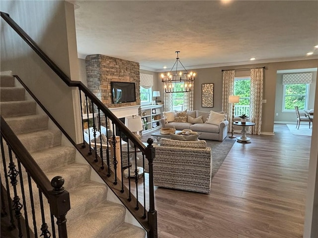 116 Mesa Dr, Moon/Crescent Twp, PA 15108 - living room featuring wood finished floors, a chandelier, a fireplace, recessed lighting, and crown molding