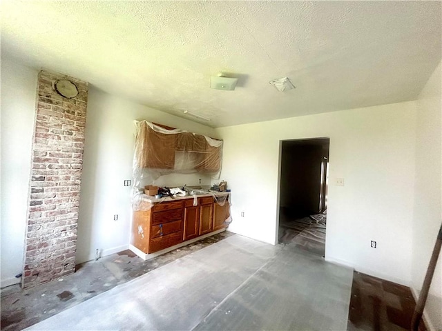 1411 Walnut Ave, Monessen, PA 15062 - kitchen featuring a textured ceiling, brown cabinets, and light countertops