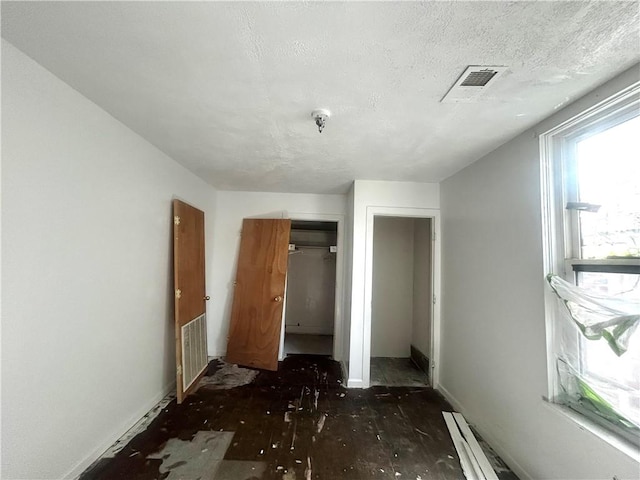 1411 Walnut Ave, Monessen, PA 15062 - unfurnished bedroom featuring a closet, a baseboard heating unit, and a textured ceiling