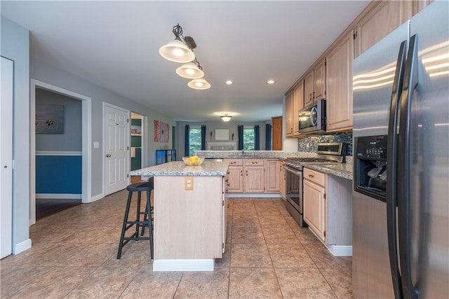 314 Westburn Ct, Seven Fields Boro, PA 16046 - kitchen with appliances with stainless steel finishes, a breakfast bar area, a peninsula, backsplash, and light tile patterned floors