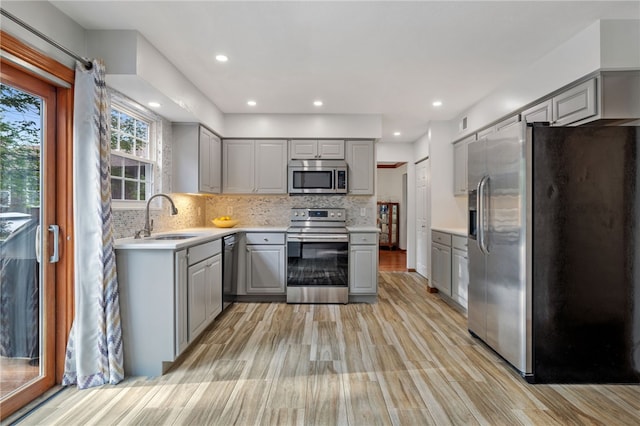 215 Lafayette Dr, Cranberry Twp, PA 16066 - kitchen featuring appliances with stainless steel finishes, gray cabinets, light wood finished floors, light countertops, and decorative backsplash