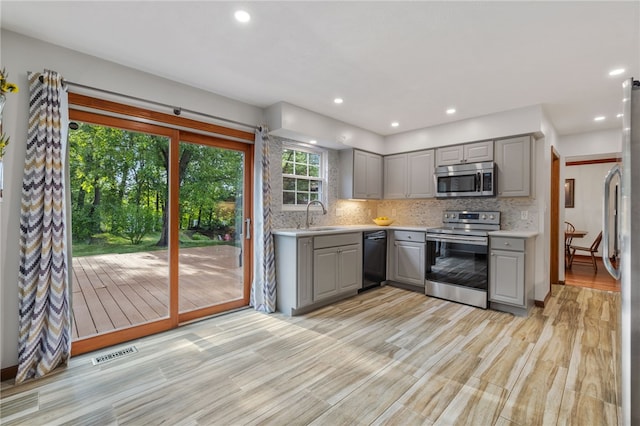 215 Lafayette Dr, Cranberry Twp, PA 16066 - kitchen featuring gray cabinets, appliances with stainless steel finishes, light countertops, tasteful backsplash, and light wood-style floors