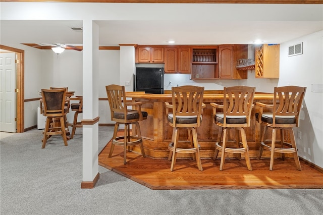 215 Lafayette Dr, Cranberry Twp, PA 16066 - kitchen featuring freestanding refrigerator, light colored carpet, a kitchen breakfast bar, ceiling fan, and brown cabinets
