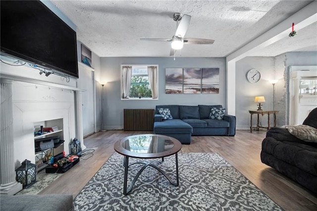 206 7th St, Oakmont, PA 15139 - living area with radiator, a ceiling fan, a textured ceiling, and wood finished floors