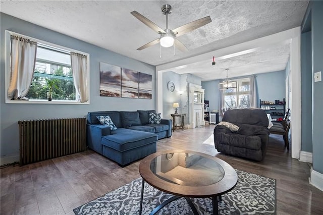 206 7th St, Oakmont, PA 15139 - living room with radiator, ceiling fan, wood finished floors, and a chandelier