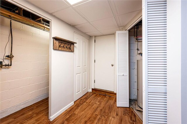 12220 Herold Dr, North Huntingdon, PA 15642 - hallway featuring wood finished floors, concrete block wall, and water heater