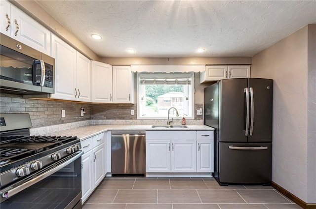 12220 Herold Dr, North Huntingdon, PA 15642 - kitchen with stainless steel appliances, light countertops, white cabinets, decorative backsplash, and light tile patterned floors