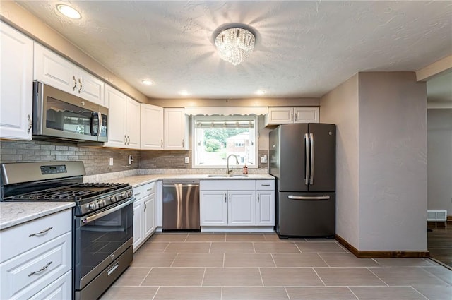 12220 Herold Dr, North Huntingdon, PA 15642 - kitchen with stainless steel appliances, white cabinetry, backsplash, and recessed lighting