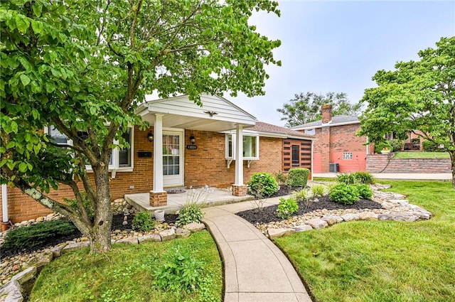 12220 Herold Dr, North Huntingdon, PA 15642 - view of front of home featuring a front yard, brick siding, a chimney, and covered porch