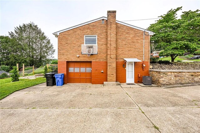 12220 Herold Dr, North Huntingdon, PA 15642 - view of side of property featuring brick siding, concrete driveway, a garage, and a chimney