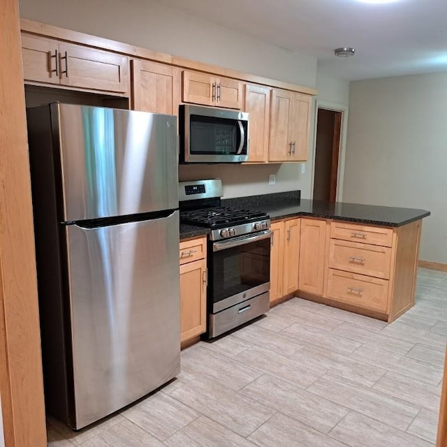 120 Rothen Ave, Twp Of But Nw, PA 16001 - kitchen featuring appliances with stainless steel finishes, light brown cabinets, a peninsula, and dark stone countertops