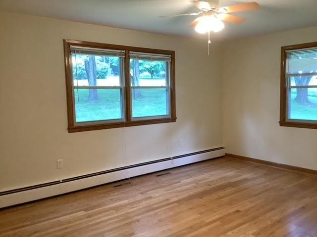 120 Rothen Ave, Twp Of But Nw, PA 16001 - spare room featuring plenty of natural light, a baseboard radiator, light wood-type flooring, and a ceiling fan