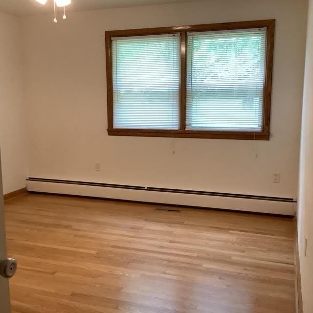 120 Rothen Ave, Twp Of But Nw, PA 16001 - empty room with light wood-style flooring and a baseboard heating unit