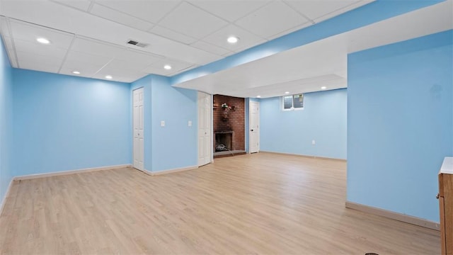 4952 Flamingo Dr, Whitehall, PA 15236 - unfurnished living room with a brick fireplace, light wood-style flooring, a paneled ceiling, and recessed lighting