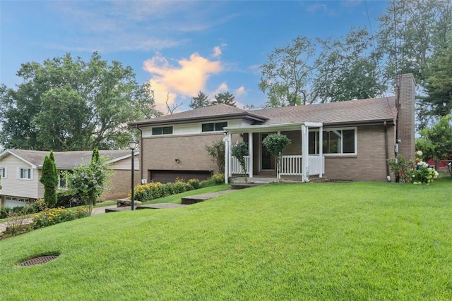 4952 Flamingo Dr, Whitehall, PA 15236 - tri-level home featuring a chimney, brick siding, a front yard, and covered porch
