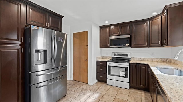 4952 Flamingo Dr, Whitehall, PA 15236 - kitchen with appliances with stainless steel finishes, dark brown cabinetry, recessed lighting, light stone countertops, and light tile patterned floors