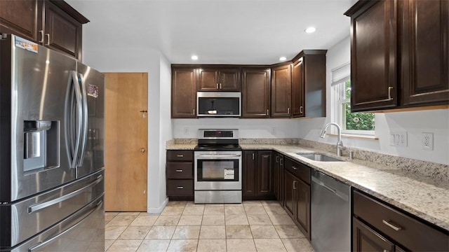 4952 Flamingo Dr, Whitehall, PA 15236 - kitchen featuring appliances with stainless steel finishes, dark brown cabinets, light stone counters, recessed lighting, and light tile patterned floors