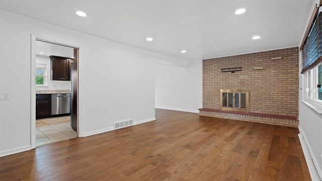 4952 Flamingo Dr, Whitehall, PA 15236 - unfurnished living room with light wood-style floors, a brick fireplace, and recessed lighting