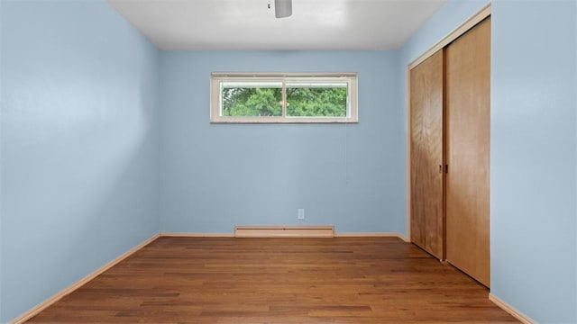 4952 Flamingo Dr, Whitehall, PA 15236 - unfurnished bedroom featuring baseboard heating, a closet, wood finished floors, and a ceiling fan