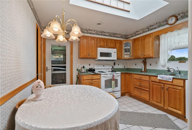1146 Middletown, Hempfield Twp, PA 15601 - kitchen with white appliances, wallpapered walls, a chandelier, a skylight, and brown cabinets
