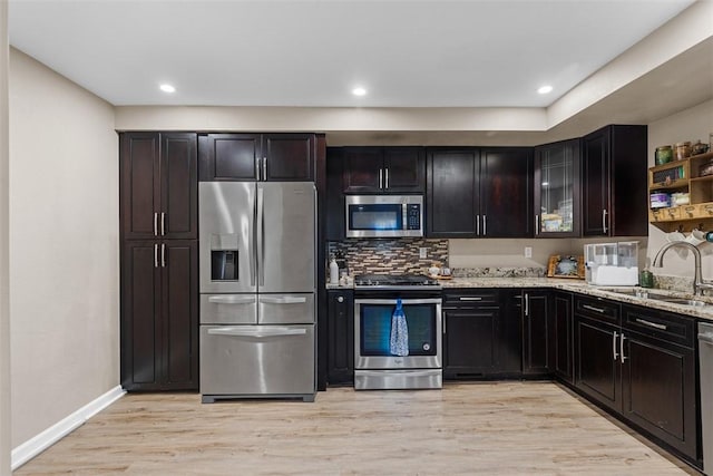 4673 Mill Stream Ct, Murrysville, PA 15668 - kitchen featuring appliances with stainless steel finishes, light stone countertops, light wood finished floors, backsplash, and glass insert cabinets