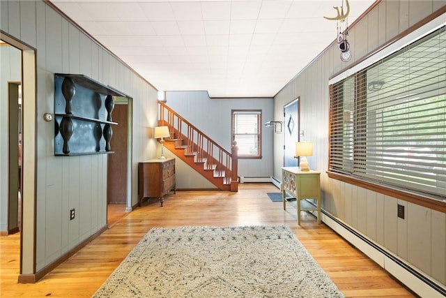 769 Russell Ave, Greater Johnstown School District, PA 15902 - entryway featuring baseboard heating, stairway, light wood-style flooring, and wooden walls