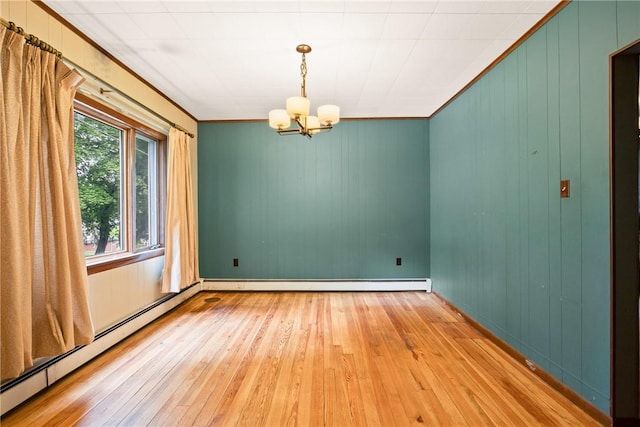 769 Russell Ave, Greater Johnstown School District, PA 15902 - spare room featuring hardwood / wood-style flooring, a baseboard heating unit, a chandelier, ornamental molding, and wood walls