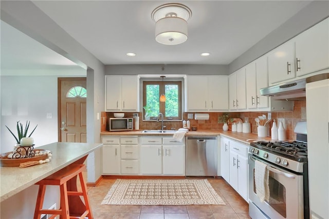 2116 Stewart Rd, South Park, PA 15129 - kitchen with stainless steel appliances, under cabinet range hood, light countertops, decorative backsplash, and white cabinetry