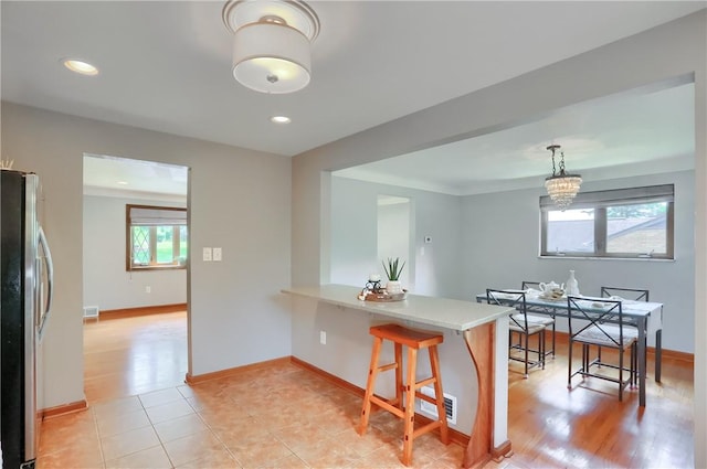 2116 Stewart Rd, South Park, PA 15129 - kitchen with freestanding refrigerator, light countertops, a kitchen breakfast bar, a peninsula, and a chandelier