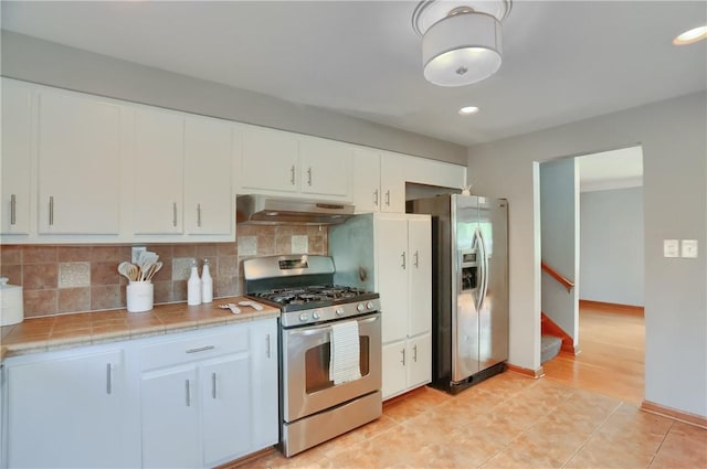 2116 Stewart Rd, South Park, PA 15129 - kitchen featuring appliances with stainless steel finishes, under cabinet range hood, tasteful backsplash, white cabinets, and recessed lighting