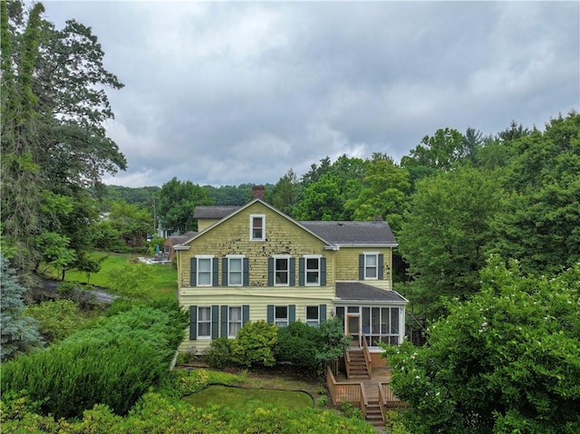 2507 Duncan Ave, Hampton, PA 15101 - view of front facade featuring a sunroom, a chimney, stairs, a forest view, and roof with shingles