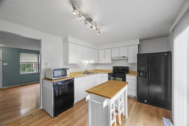 301 Laporte Ct, Cranberry Twp, PA 16066 - kitchen with black appliances, white cabinets, light wood finished floors, under cabinet range hood, and rail lighting
