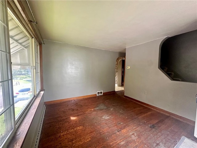 853 5th St, East Rochester, PA 15074 - unfurnished room featuring hardwood / wood-style flooring, arched walkways, and a baseboard heating unit