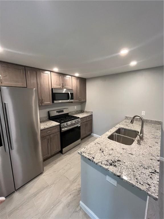 446 Enright Ct, East Liberty, PA 15206 - kitchen with stainless steel appliances, a peninsula, light stone countertops, recessed lighting, and dark brown cabinetry