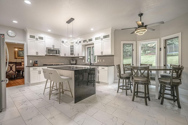 117 Cidar Ln, Peters Twp, PA 15317 - kitchen featuring stainless steel appliances, light marble finish flooring, dark countertops, a ceiling fan, and white cabinets