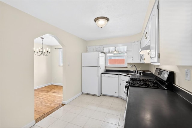 228 Mcmasters Dr, Monroeville, PA 15146 - kitchen with white appliances, dark countertops, arched walkways, and plenty of natural light