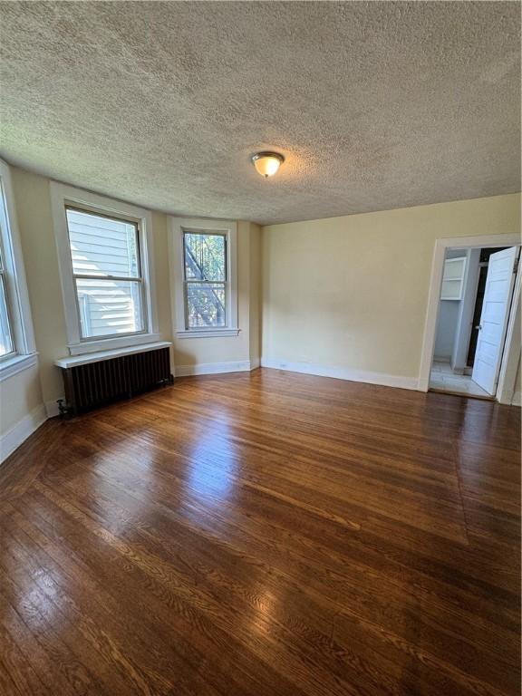 207 N Sprague Ave, Bellevue, PA 15202 - empty room featuring radiator heating unit, wood finished floors, and a textured ceiling