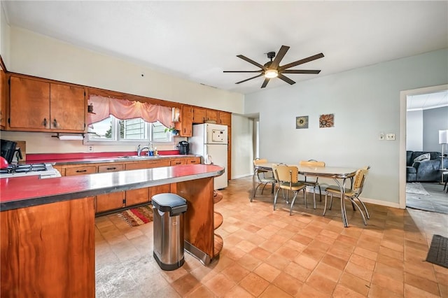 61 S 10th St, Sharpsville, PA 16150 - kitchen featuring freestanding refrigerator, ceiling fan, brown cabinets, and gas range oven