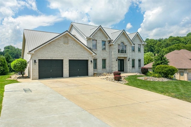 1007 Cicero Dr, Hempfield Twp, PA 15642 - traditional home with brick siding, driveway, a garage, a front lawn, and a metal roof