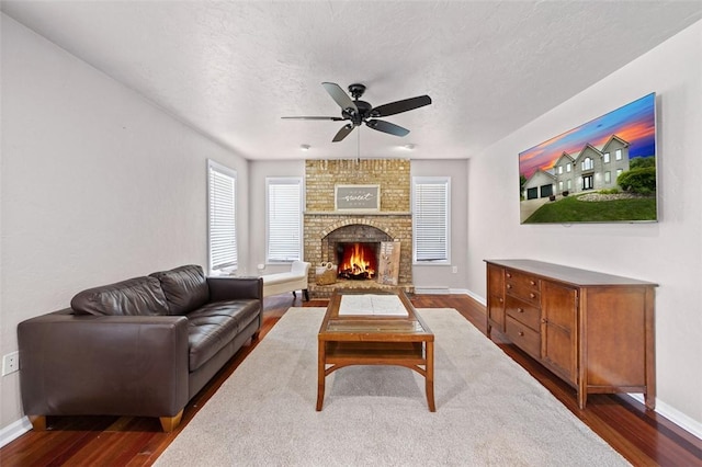 1007 Cicero Dr, Hempfield Twp, PA 15642 - living area featuring ceiling fan, dark wood finished floors, a brick fireplace, and a textured ceiling
