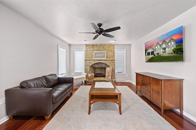1007 Cicero Dr, Hempfield Twp, PA 15642 - living area with a ceiling fan, dark wood-type flooring, a brick fireplace, and a textured ceiling